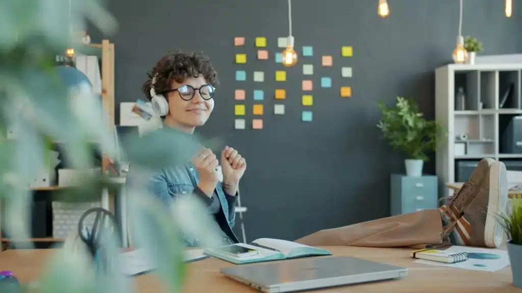 Salariée détendue et souriante à son bureau, illustrant le bien-être au travail